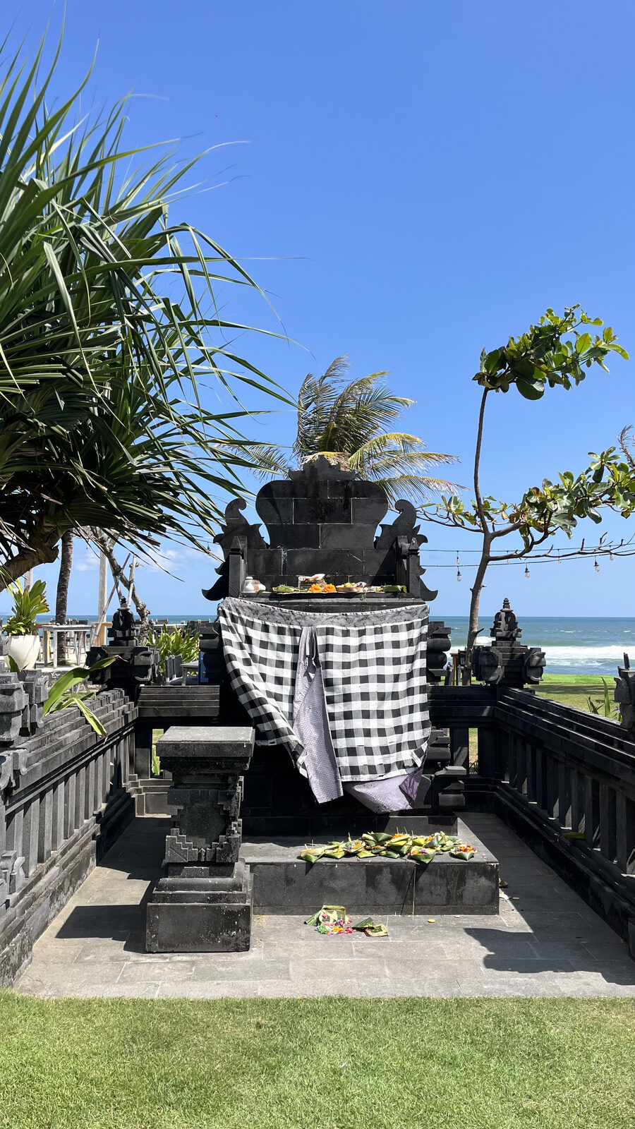 Altar balinés con ofrendas frente al mar en Seseh